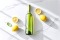Fresh lemons and a green bottle are positioned on a white marble surface, with strong sunlight shining down, casting shadows and Royalty Free Stock Photo