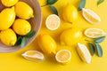 Fresh lemons with green leaves on the yellow background Royalty Free Stock Photo