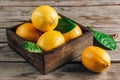 Fresh lemons in an old box with leaves on rustic wooden background Royalty Free Stock Photo