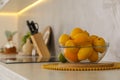 Fresh lemons and orange in glass bowl on white table in kitchen, space for text Royalty Free Stock Photo