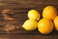 Fresh lemons and oranges on brown wooden table. Royalty Free Stock Photo