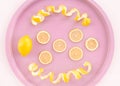 Lemons and spiral peel on a pink tray