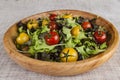 Fresh lettuce and red and yellow cherry tomatoes on a wooden tray Royalty Free Stock Photo