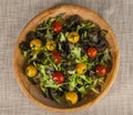 Fresh lettuce and red and yellow cherry tomatoes on a wooden tray Royalty Free Stock Photo