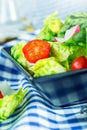 Fresh lettuce salad with cherry tomatoes radish and carafe with olive oil on wooden table. Royalty Free Stock Photo