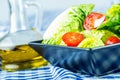 Fresh lettuce salad with cherry tomatoes radish and carafe with olive oil on wooden table. Royalty Free Stock Photo