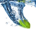 Fresh lime dropped into blue water Royalty Free Stock Photo