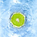 Fresh lime dropped into water Royalty Free Stock Photo