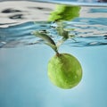 Fresh lime dropped into water with splash isolated on blue Royalty Free Stock Photo