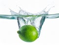 Fresh lime dropped into water with splash isolated on white Royalty Free Stock Photo