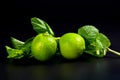 Fresh lime fruits and mint leaves on a black background. Citrus fruit Royalty Free Stock Photo