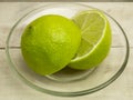 Fresh lime in a glass plate on a wooden background Royalty Free Stock Photo