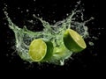 Fresh lime and juice splash on black background