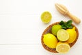 Fresh lime and lemon in basket with citrus juicer stick on white. Preparation ingredient for cooking with lime and lemon Royalty Free Stock Photo