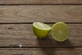 Fresh limes sliced in half on wooden background. Royalty Free Stock Photo