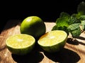 Fresh limes sliced in half on vintage wooden background. Royalty Free Stock Photo