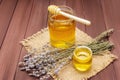 Fresh liquid honey in glass jars with a wooden honey dipper