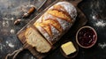 A fresh loaf of artisanal bread placed on a rustic cutting board with butter and jam. digital Royalty Free Stock Photo