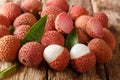 Fresh lychee and peeled showing the red skin and white flesh with green leaf. horizontal Royalty Free Stock Photo