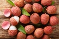 Fresh lychee and peeled showing the red skin and white flesh with green leaf. Horizontal top view Royalty Free Stock Photo