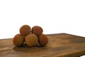 Fresh lychee and peeled showing the red skin and white flesh with green leaf on a wooden background. Lychi with leaves - tropical