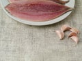 Fresh mackerel fillets on a white plate, Garlic cloves. Cooking fish concept Royalty Free Stock Photo