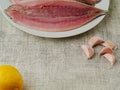 Fresh mackerel fillets on a white plate, Garlic cloves and lemon . Cooking fish concept Royalty Free Stock Photo