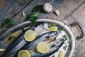 Fresh mackerel fish with lemon and spices served on silver plate from above. Homemade seafood dish recipe cooking