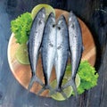 fresh mackerel fish vegetables on a wooden board