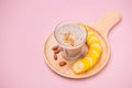 Fresh made banana smoothie in a glass on pink background Royalty Free Stock Photo