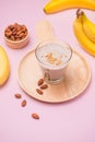 Fresh made banana smoothie in a glass on pink background Royalty Free Stock Photo