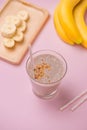 Fresh made banana smoothie in a glass on pink background Royalty Free Stock Photo