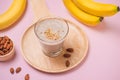 Fresh made banana smoothie in a glass on pink background Royalty Free Stock Photo