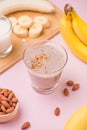 Fresh made banana smoothie in a glass on pink background Royalty Free Stock Photo