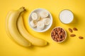 Fresh made banana smoothie in a glass on yellow background Royalty Free Stock Photo