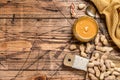 Fresh made creamy Peanut Butter in a glass jar. Wooden background. Top view. Copy space Royalty Free Stock Photo