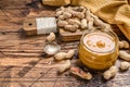 Fresh made creamy Peanut Butter in a glass jar. Wooden background. Top view. Copy space Royalty Free Stock Photo