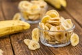 Portion of Dried Banana Chips on wooden background, selective focus Royalty Free Stock Photo