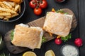 Fresh made Snack Sandwich with Fish Sticks, on wooden cutting board, on black wooden table background, top view flat lay Royalty Free Stock Photo