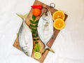 Fresh Malabar Trevally fish decorated with herbs and fruits on a wooden pad ,Isolated on white Background.Selective focus Royalty Free Stock Photo