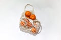Fresh mandarines in a string bag, eco-friendly product on a light background. Royalty Free Stock Photo