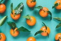 Fresh mandarins with leaves on turqoise background