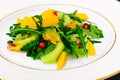 Fresh mango, arugula, kiwi, orange and pomegranate. Royalty Free Stock Photo