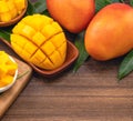 Fresh mango,beautiful chopped fruit with green leaves on dark wooden table background. Tropical fruit design concept. Flat lay. Royalty Free Stock Photo