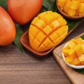 Fresh mango, beautiful chopped fruit with green leaves on dark wooden table background. Tropical fruit design concept. Flat lay. Royalty Free Stock Photo