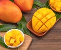 Fresh mango, beautiful chopped fruit with green leaves on dark wooden table background. Tropical fruit design concept. Flat lay. Royalty Free Stock Photo
