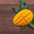 Fresh mango,beautiful chopped fruit with green leaves on dark wooden table background. Tropical fruit design concept. Flat lay. Royalty Free Stock Photo