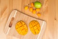 Fresh mango on a cutting board with Fresh Kumquats and a lime, on a wooden table Royalty Free Stock Photo