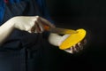 Fresh mango in the hands of the cook. Exotic fruit. Ripe mango. Balanced diet. Dark background. Space for text Royalty Free Stock Photo