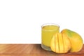 Fresh mango juice with ripe sliced mangoes on a wooden table with a white background Royalty Free Stock Photo